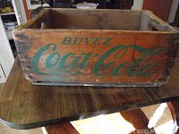 Top down front view of the vintage wooden Coca-Cola crate showing logo and aged wood condition