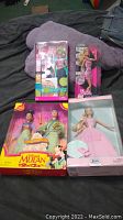 Four Barbie dolls in their original packaging including Disney Mulan, NSYNC, Gymnastics Barbie, and another Barbie in pink dress