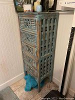 Front and side view showing decorative drawer fronts and weathered paint.