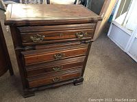 Front view of vintage four drawer dresser with dark wood finish and metal drawer handles.