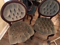 Pair of vintage parlor chairs with green velvet upholstery and mahogany frame showing full seating and backrest details.
