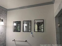 Three framed mirror pieces hanging on a wall, showing the full set in context.