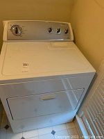 White Whirlpool dryer full front view showing the appliance body and door.