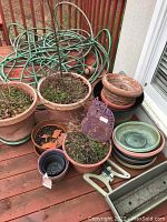 Overview of garden pots, hose, sprinkler and metal cat ornament