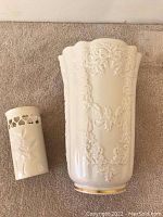 Two Lenox vases side by side on carpet, showing size difference and designs.