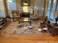 Full view of the area rug placed in a living room under a glass coffee table, showing overall condition and design.
