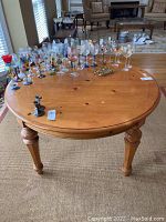 Top view of the round wooden dining table with glassware on top showing the table surface and condition.