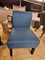 Front view of a blue upholstered chair showing seat, backrest, and wooden legs
