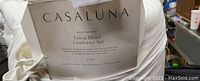 Close-up photo of the Casaluna heavy weight linen blend comforter set label showing brand and details.