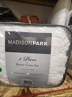 Packaged Madison Park branded white 3-piece duvet cover set including label showing full/queen and king/cal king sizes.