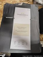 Photo showing gray folded sheet set with Threshold branded paper label describing it as Performance Sheet Set with classic comfort, shrink resistance, and easy care convenience.