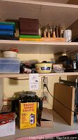 Woodworking tools on shelving including a box labeled 'Router Speed Control', cords, and containers mostly opaque, shelving setup in room.