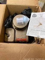 Motor inside original cardboard box with protective black plastic bags. Motor housing appears in beige with label showing 5 HP and 4-Cycle Wards Powr-Kraft branding. Includes printed service and repair information sheet.