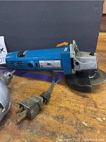 Photo showing Chicago Electric 4-1/2 inch angle grinder with label and power cord