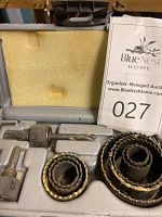 Photo of holesaw kit showing various saw blade sizes, arbor with pilot drill bit, chuck key, housed in a molded plastic case with foam insert