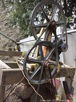 Close-up showing two large metal pulleys and rubber belts part of the rotary drive system for the sifter.