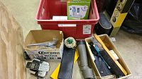 Various items including digital cordless phone, flashlight, long scope/telescope part, and several small boxes and containers in two bins.