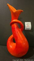 Full front view of the red-orange flame serpent vase showing its twisted body and flared top.