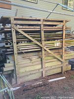 Front view of wooden rack loaded with stacked pressure-treated lumber outdoors