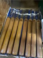 Set of 8 wood turning chisels with wooden handles in a blue plastic holder