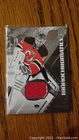 Front of Cory Schneider game used jersey card showing player image and red fabric swatch