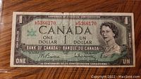 Front side of a 1967 Canadian Centennial one dollar bill showing Queen Elizabeth II, serial number, and bank officials' signatures.
