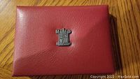 Red leather Royal Mint pouch with crest embossed on front.