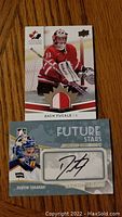 Front view of two hockey cards: Zach Fucale game used jersey card and Dustin Tokarski Future Stars autographed card.