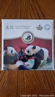 Front of the presentation package showing the coloured panda coin and panda imagery