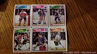 Photo showing six 1988-1989 Topps hockey cards featuring Mike Gartner, Grant Fuhr, Dale Hunter, Denis Savard, Michel Dionne, and Guy Lafleur.