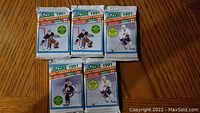 Five sealed unopened 1991 Score NHL hockey card packs from Series 2, showing packaging with player images and brand labeling
