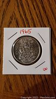 Reverse side of the 1965 Canadian silver 50 cent coin showing Canadian coat of arms and denomination.