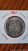 Front side of the 1960 Canadian silver 50 cent coin showing the Canadian coat of arms and denomination.