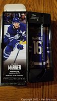 Miniature hockey stick in open box with image of Mitch Marner and player details on packaging