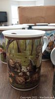 Close-up photo of a Boyds Bear ceramic mug showing detailed bear illustrations in a forest scene with baskets and fishing theme