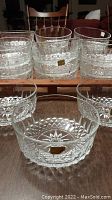 Front view of several clear glass Arcoroc Diamant Starburst bowls with labels visible, stacked on a wooden surface.