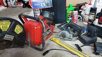 Concrete saw, cordless saw, level and assorted packaging on floor