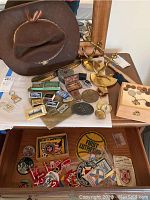 Overall view of hat, bookends, coins, keychains, blades, and patches.