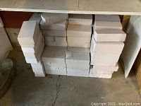 Stack of solid white bricks in garage, showing quantity and bulk