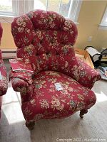 Full view of the red floral upholstered Ethan Allen armchair with tufted back and fabric arm covers.