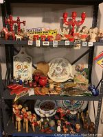 Three-tier metal shelving unit with assorted Dala horses, candelabra and ceramic busts