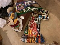 Photo of assorted vintage pennants and fabric hats laid on a floor