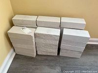 33 solid white bricks stacked in piles, showing smooth surfaces.