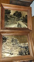Two small wooden framed prints depicting sepia toned rustic landscapes.