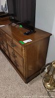 Angle view of plain drawers side of dresser with TV on top