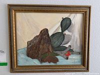 Full view of the framed original painting showing cactus, red flower, rocks, and background with signature visible.