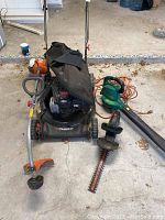 Photo showing the Murray lawn mower with Briggs and Stratton engine, Black & Decker hedge trimmer, string trimmer, and blower.