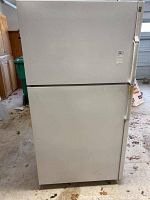 Front view of a white top freezer refrigerator with minor dirt marks.