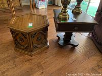 Octagon and square wooden side tables shown together on hardwood floor with two brass lamps on square table.