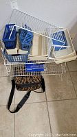 Lot displaying white wire racks with multiple blue and beige plastic baskets and trays, with a patterned cloth cosmetic bag at the bottom.